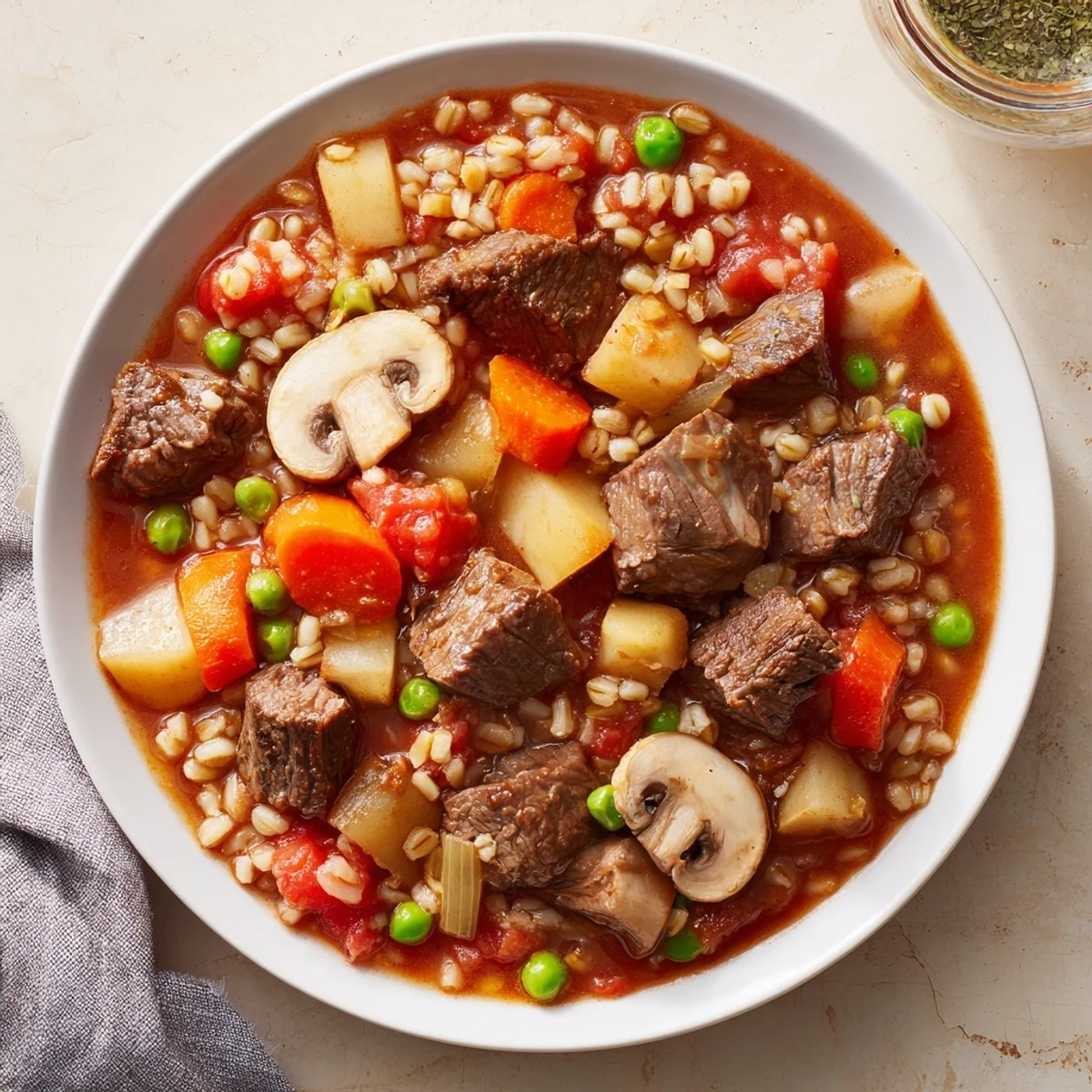 Close-up of bubbling beef and barley stew, showcasing the rich broth and hearty ingredients.
