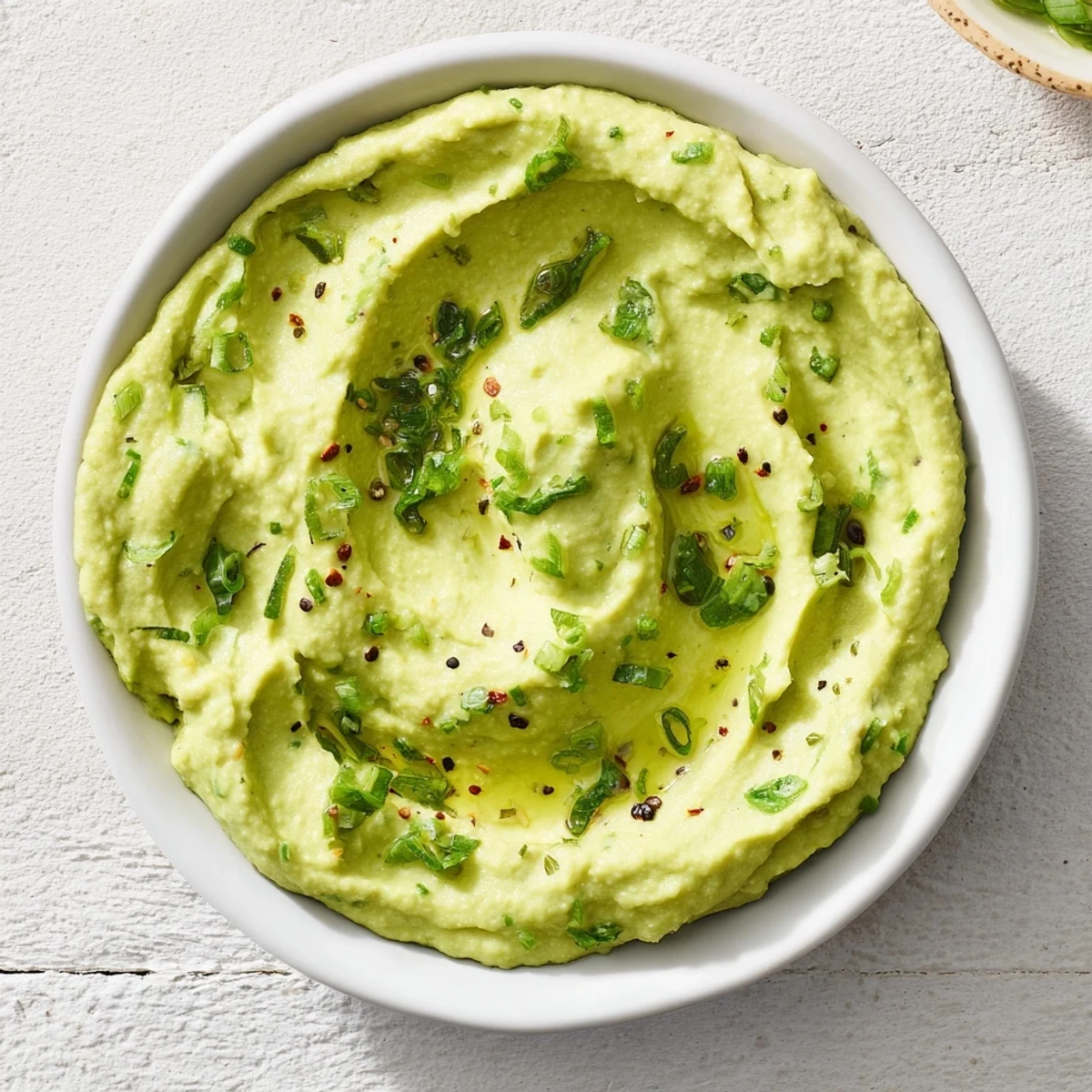 Creamy Avocado Lime Dressing: A bright green, luscious dressing with visible cilantro flecks, ready to drizzle.