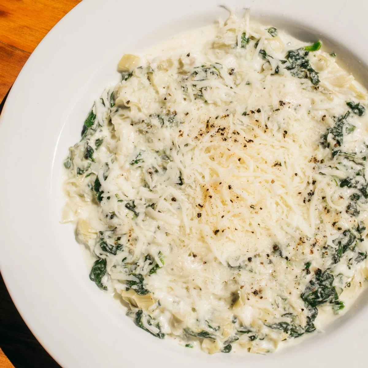 A warm, shareable dish: creamy cheesy spinach and artichoke dip, perfect for a party appetizer.