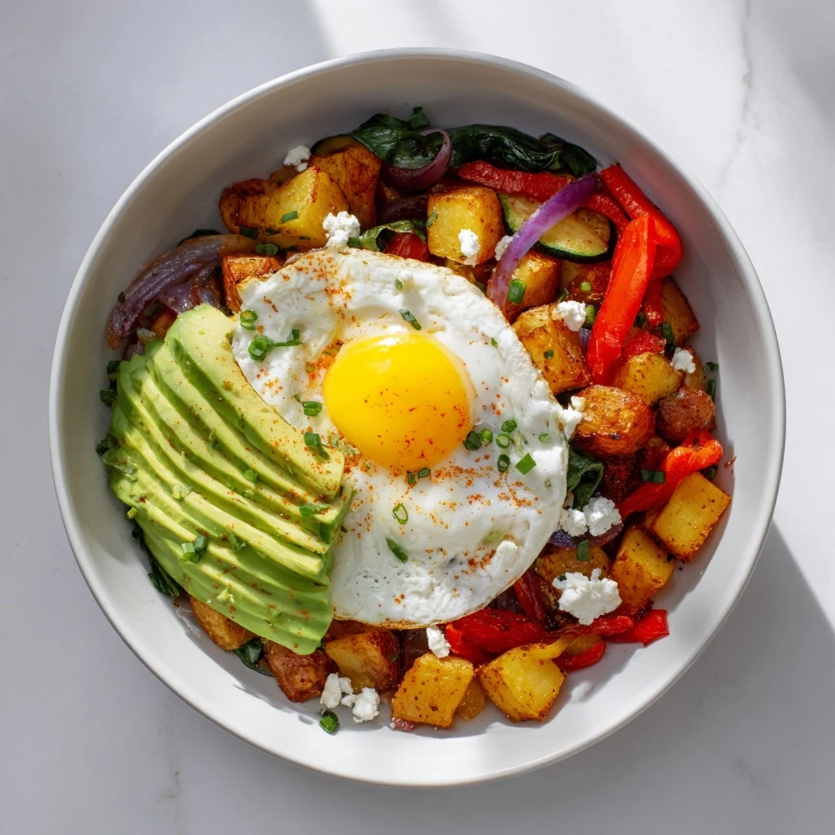 Hearty savory breakfast bowl featuring perfectly cooked eggs alongside colorful sautéed vegetables.