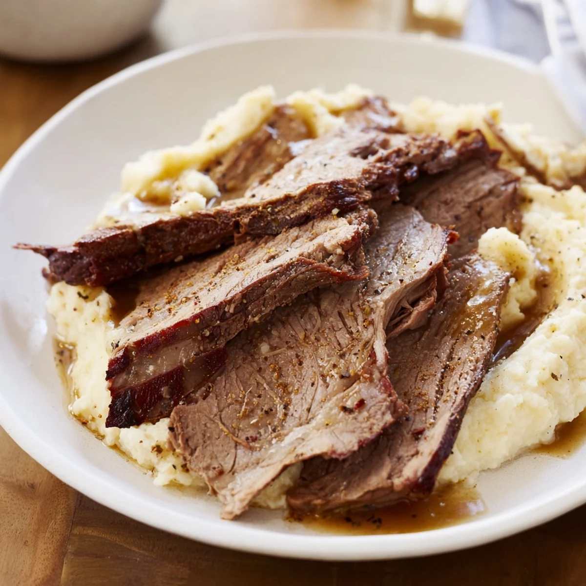 Mouthwatering image of slow-cooked beef brisket with tender sweet potato mash, ready to be enjoyed.