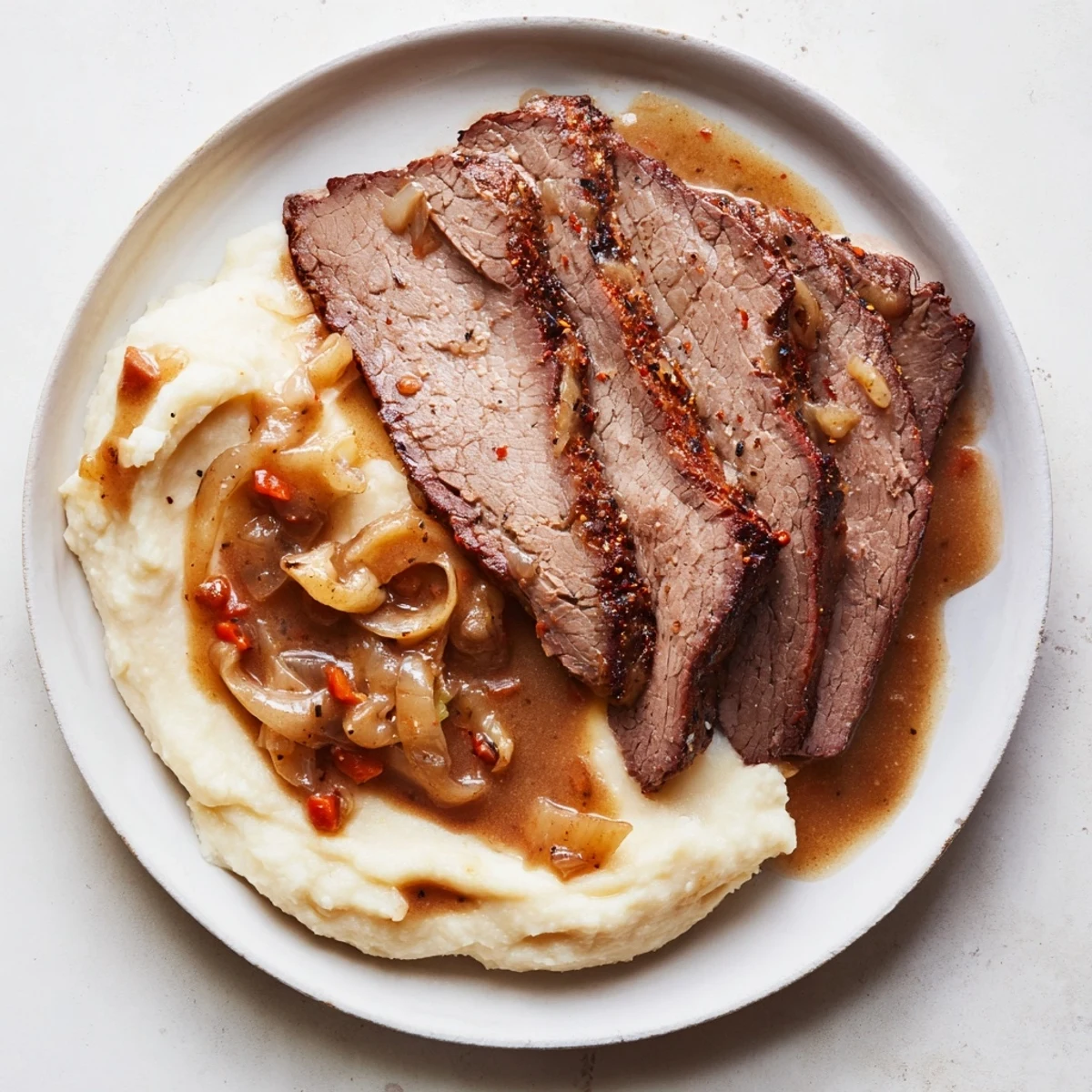 Fork-tender beef brisket nestled atop creamy sweet potato mash, offering a comforting family dinner.