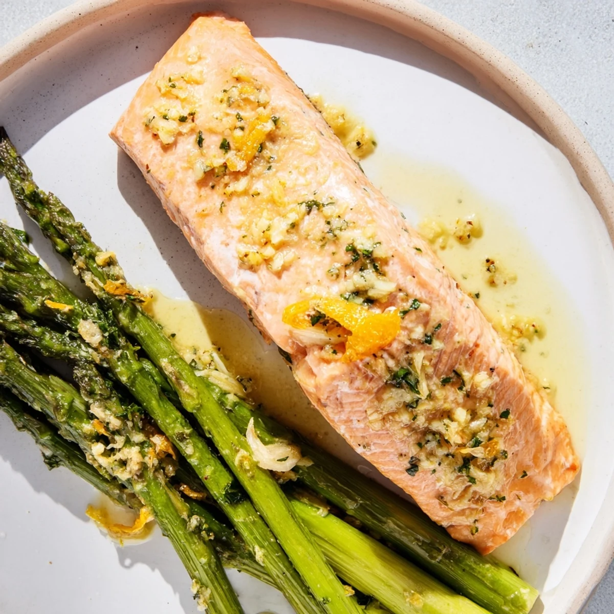 Golden-brown Lemon Garlic Butter Salmon basking alongside vibrant green asparagus, a tasty meal.