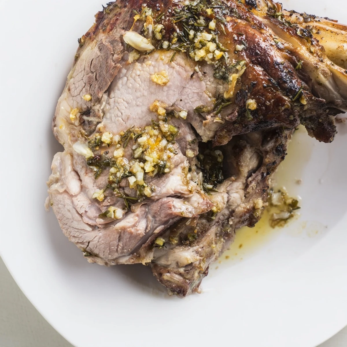 Fragrant herbs and lemon zest perfume this slow-roasted lamb shoulder, beautifully browned and sliced for serving.
