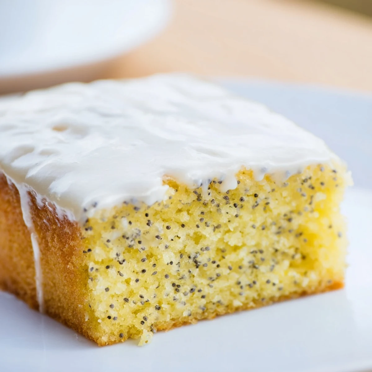 Homemade Lemon Drizzle Traybake with Poppy Seeds topped with zesty glaze and lemon zest, moist crumb perfect for dessert platters.