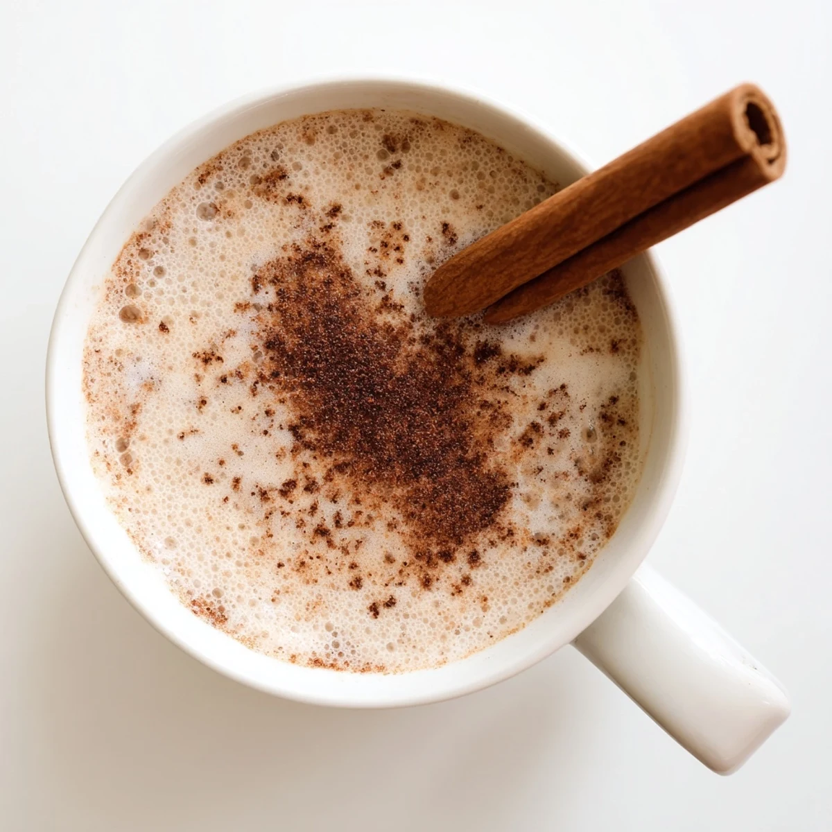 Steaming Spiced Chai Tea Latte with cinnamon on a rustic wooden table.