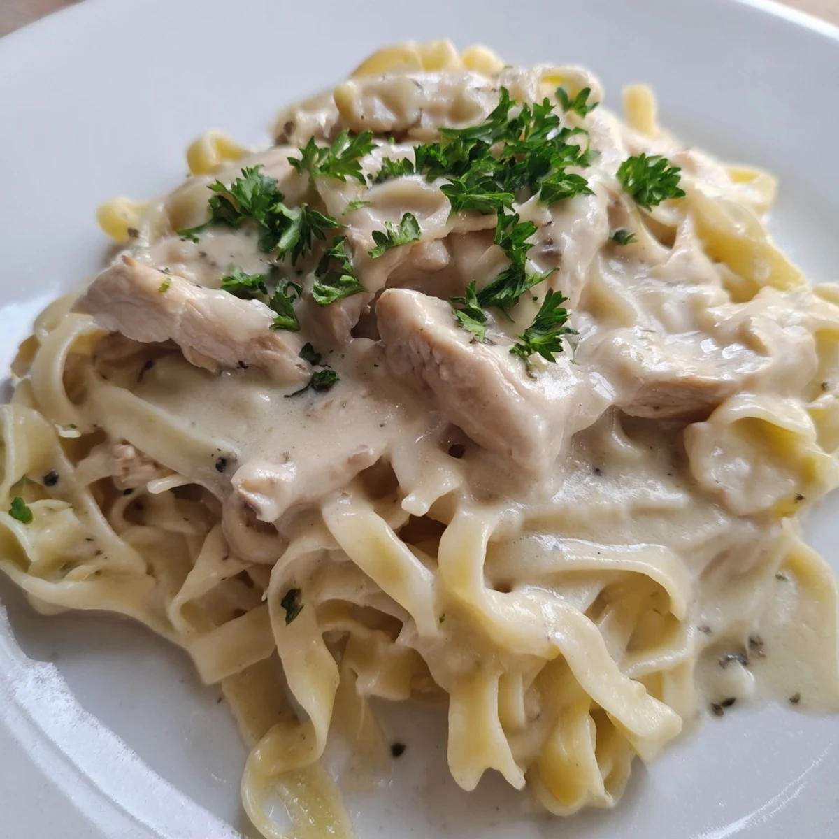 Creamy Chicken Alfredo plated with fettuccine and extra grated Parmesan, perfect for a family dinner.