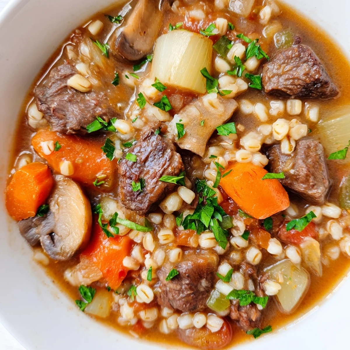 Thick, rustic Hearty Beef and Barley Stew with Parsnips steaming in a bowl with crusty bread.