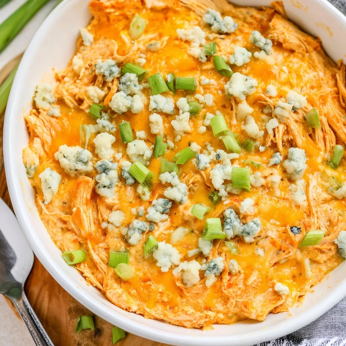 Creamy and spicy Touchdown Buffalo Chicken Dip baked until bubbling, garnished with fresh green onions and served with crunchy celery sticks for game day.  