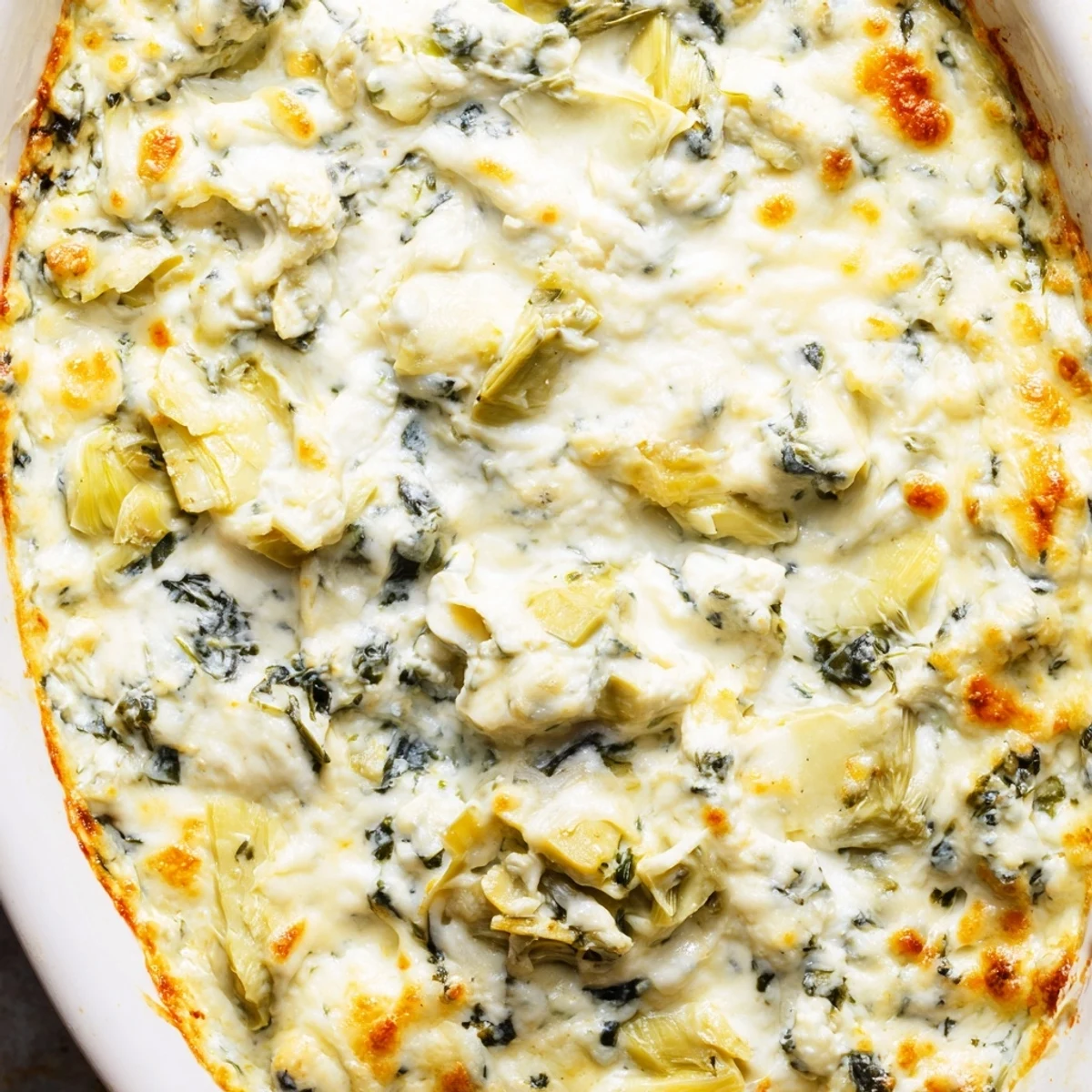Golden, bubbly Cheesy Spinach and Artichoke Dip emerges from the oven, paired with crisp toasted baguette slices ready for dipping.