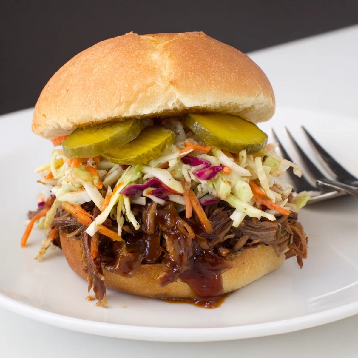 Tender, slow-cooked brisket sliders topped with tangy coleslaw and crisp pickles, served warm for a casual American gathering.  