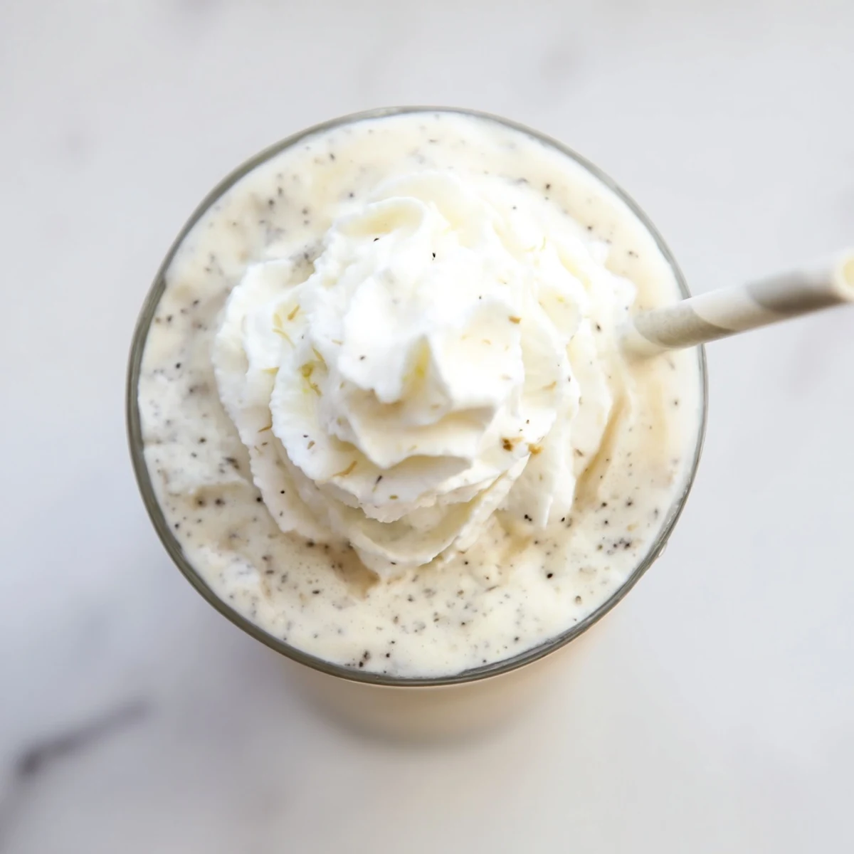 Cold, frosty Vanilla Bean Frappuccino blended with ice and milk, ready to sip on a warm day.