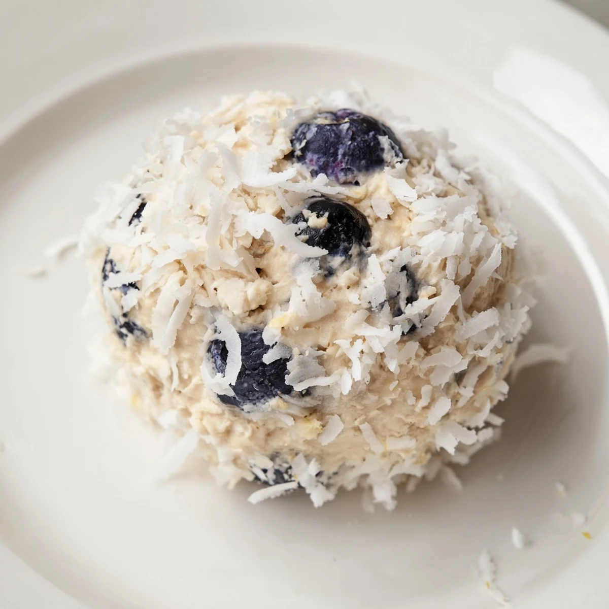 A close up of Lemon Blueberry Cottage Cheese Protein Bites on a marble counter.