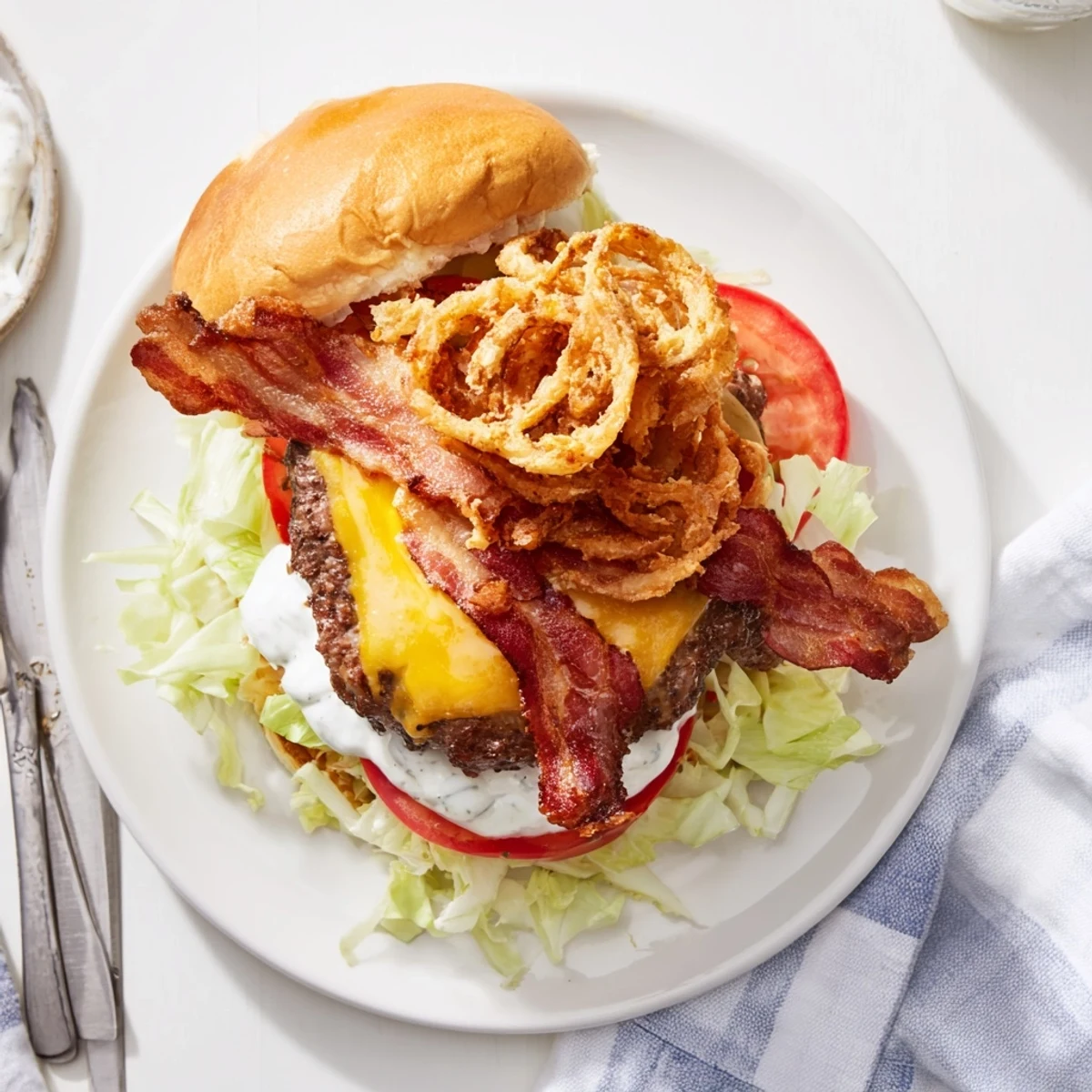 Plate these American burgers with crunchy fried onions and pickles on a checkered tablecloth.