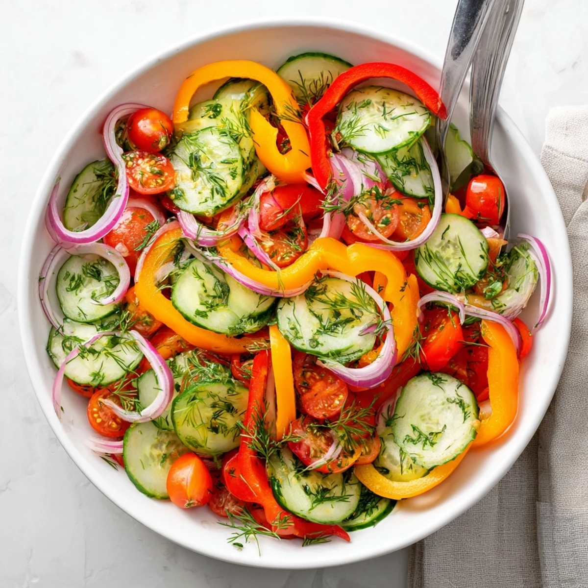 Summer cucumber and sweet pepper salad tossed with parsley and dill in olive oil dressing