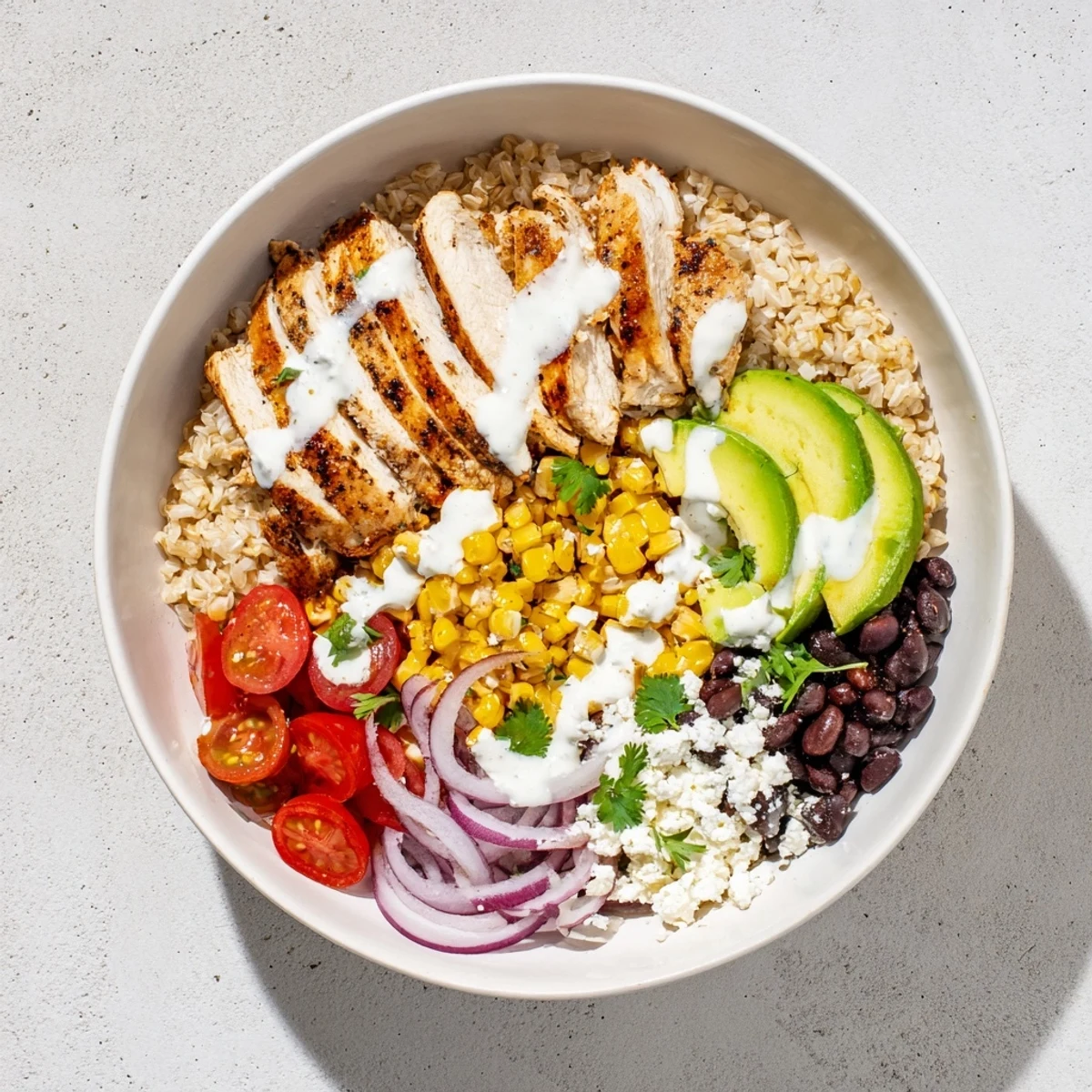 Colorful protein packed street corn chicken bowl with grilled chicken, charred corn, black beans, avocado, and creamy lime drizzle over rice