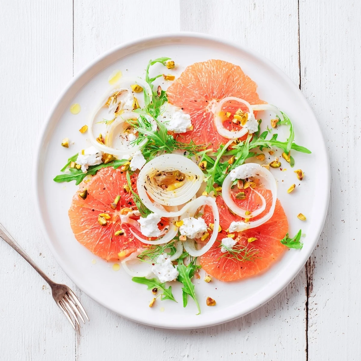 Fresh grapefruit goat cheese fennel salad plated with toasted nuts and light honey lemon dressing