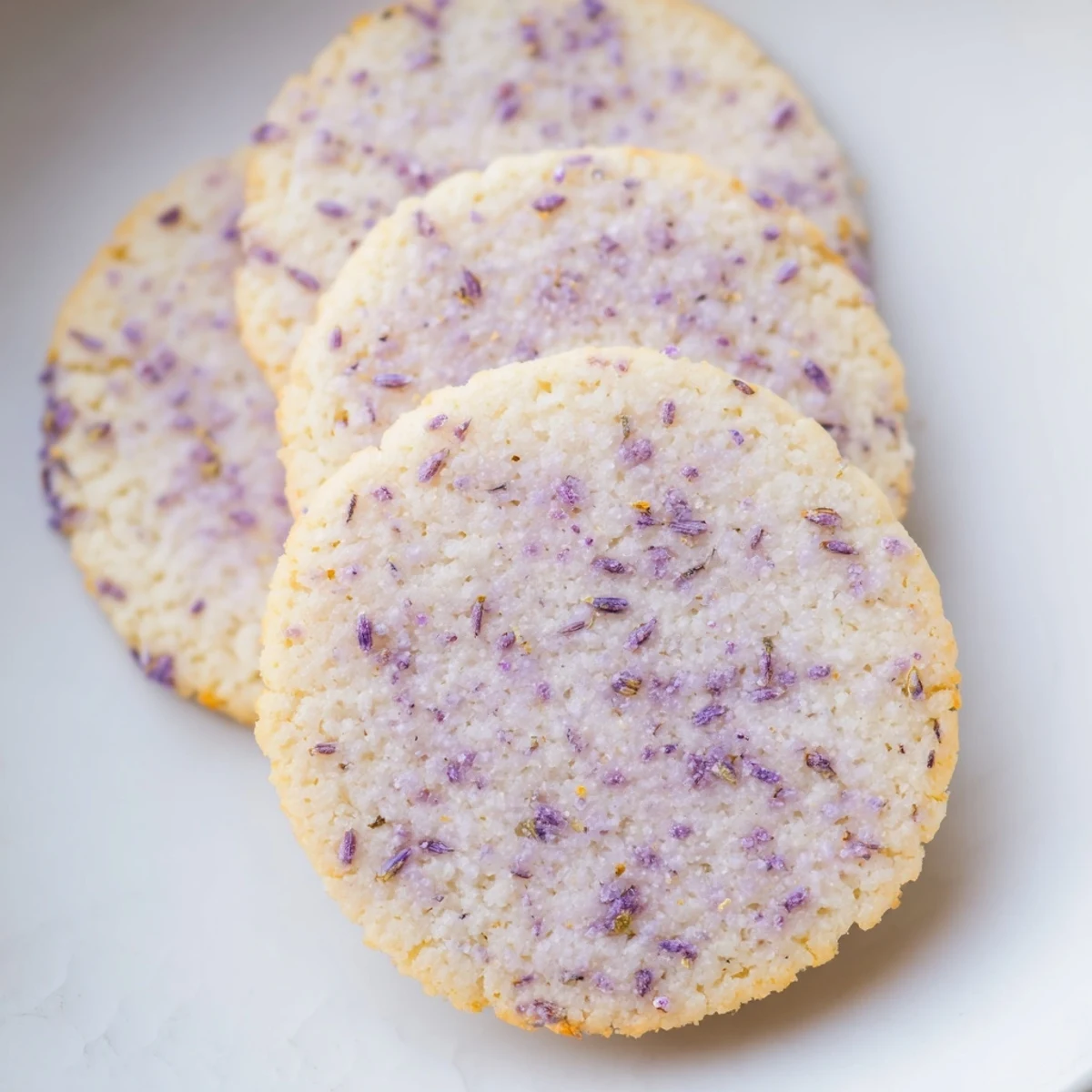 Fragrant lilac sugar cookies topped with sparkling sugar crystals on a wooden board