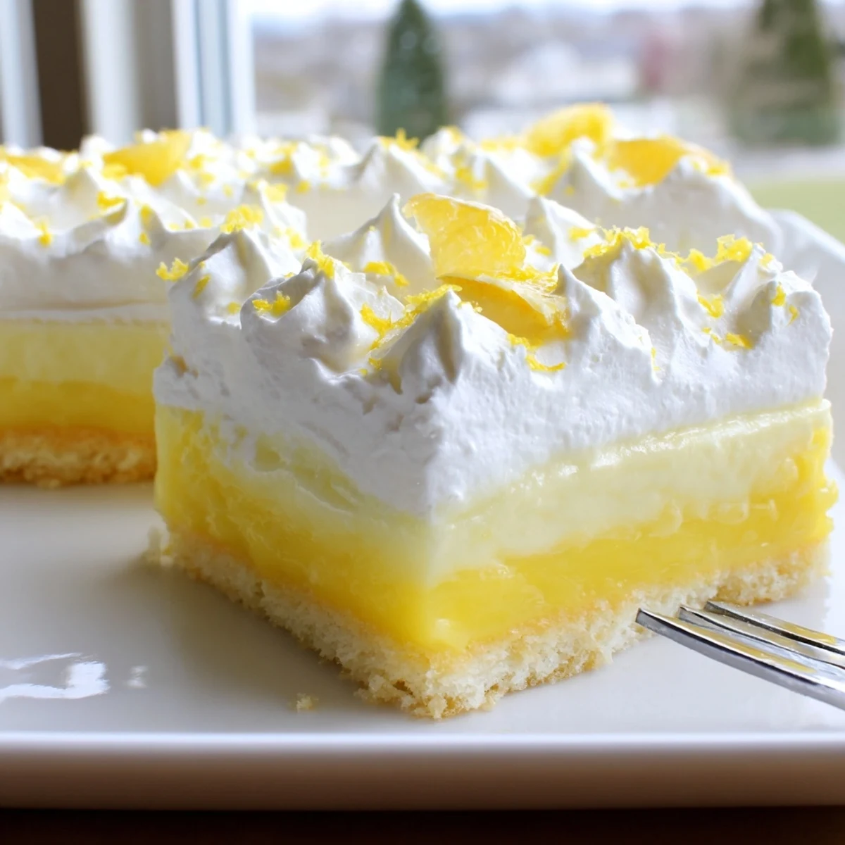 Square slice of Lemon Lush Cake showcasing buttery crust, creamy lemon filling, and fluffy white whipped topping